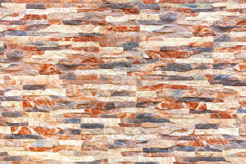 Multi colored decorative stones arranged on the wall as background, texture, pattern.