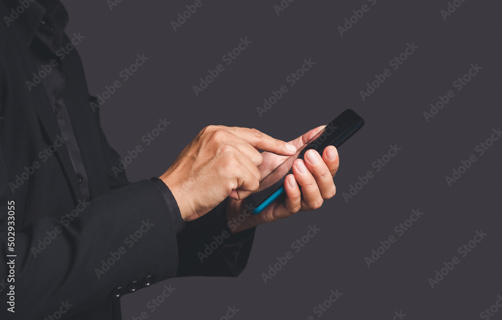 Poster close-up of hands businessman in a suit using a mobile phone while standing over a gray background
