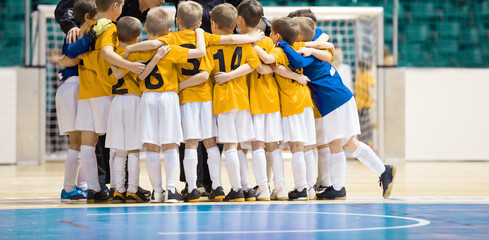 Coach giving young soccer futsal team advices before soccer tournament game stars. Indoor football...
