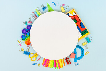 Round frame with stationery on the blue background, flatlay, copyspace
