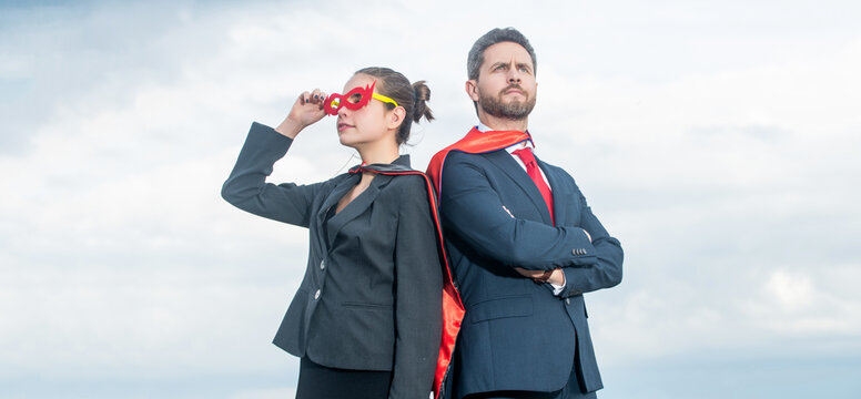 successful business couple in superhero suit on sky background