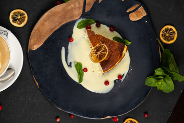 Classic cheesecake on a black background, dessert on a black background in a black plate, Latte coffee in a white cup