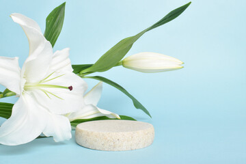 Stone podium with white lily flowers. Presentation of eco-products and cosmetics. copy space