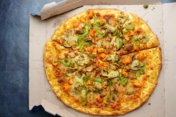  top view of cheese and chicken pizza on take away box