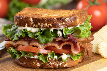 Bacon, lettuce and tomato sandwich on a cutting board - 502938003