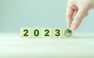 2023; Green business, enviromental sustainability. Carbon offset and neutrality strategies.  2023 written on wooden cubes and green community. Goals,plan,opportunity, new green business and social.