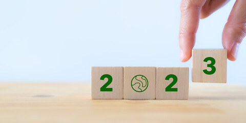 2023; Green business, enviromental sustainability. Carbon offset and neutrality strategies.  2023 written on wooden cubes and green community. Goals,plan,opportunity, new green business and social.