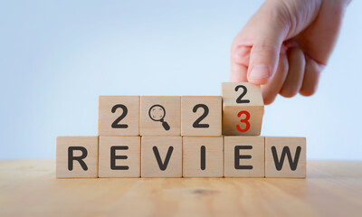 2023 Review concept. For business planning. Hand flips a wooden cube and changes the inscription...