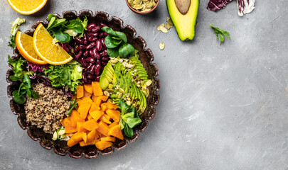 Quinoa salad in bowl with avocado, sweet potato, beans on gray background. superfood concept. Healthy, clean eating concept. Vegan or gluten free diet. top view