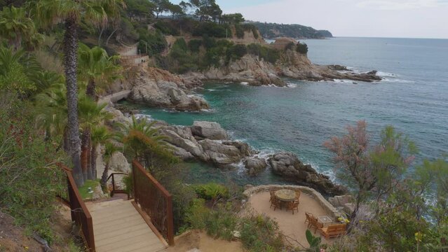 Cala Banys In Lloret De Mar Views Of The Rocky Beach Mediterranean Sea Transparent Turquoise Blue Water Spectacular Restaurant On The Seafront With Chill Out Chairs With Direct Views Of The Cliff