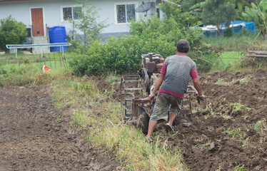 Farmers are preparing the soil for growing local vegetables using walk-behind tractors and the...