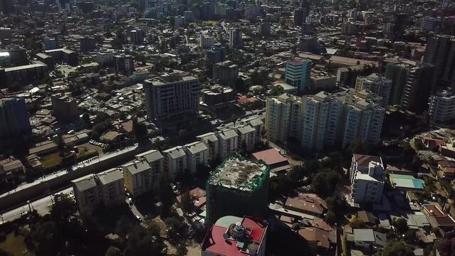 Aerial over Addis Ababa cityscape, tilt down to cars passing on city highway in busy Bole district. Transportation scene Ethiopia, Africa