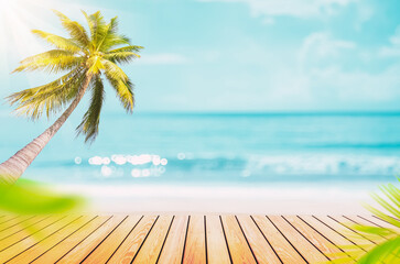 Blur tropical beach with bokeh sun light wave and palm tree on empty old wood table abstract background.