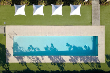 top down drone shot of a pool and umbrellas