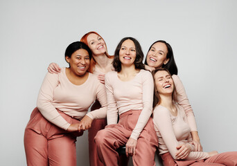 Happy excited women of different ethnicities laughing together against white background - obrazy, fototapety, plakaty