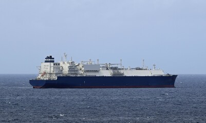 Large blue and white liquid gas Tanker ship in the ocean, blue sky in the background