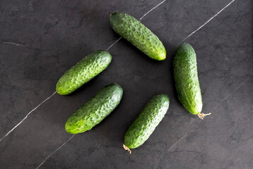 Large cucumbers on a black tabletop. Vegetables. Diet