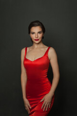 Fototapeta premium Perfect stylish model woman in red silky dress on black