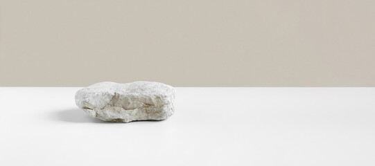 Stone Podium for promotion on gray Background. Natural pedestal. One rock podium. Beauty product mockup. Scene to show products. Showcase, display case. Front View, soft shadow