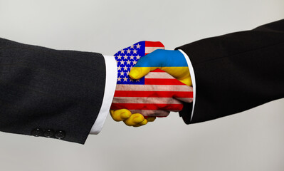 Handshake with flags of Ukraine and USA. Peace talks and negotiations concept