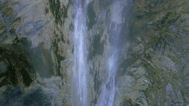 Stream water falling in deep dark gorge waterfall