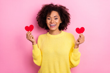 Photo of sweet funky woman dressed kitted pullover holding two red small hearts isolated pink color background