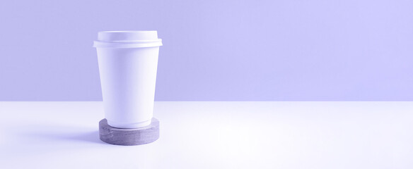 Front view of a White coffee paper cup. Mockup with lid. Paper cups for coffee or tea on violet...