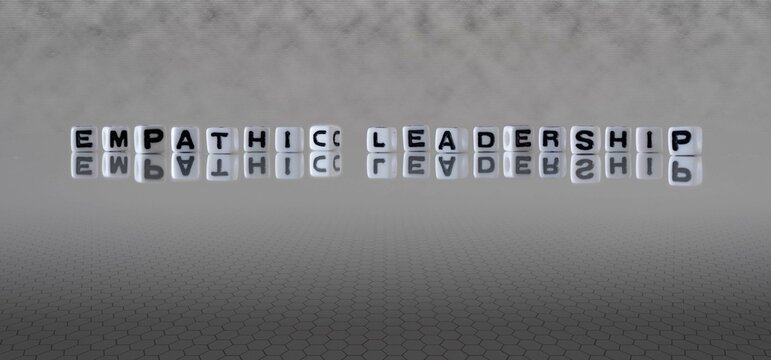 empathic leadership word or concept represented by black and white letter cubes on a grey horizon background stretching to infinity