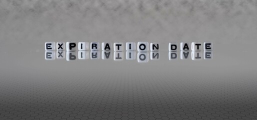 expiration date word or concept represented by black and white letter cubes on a grey horizon...