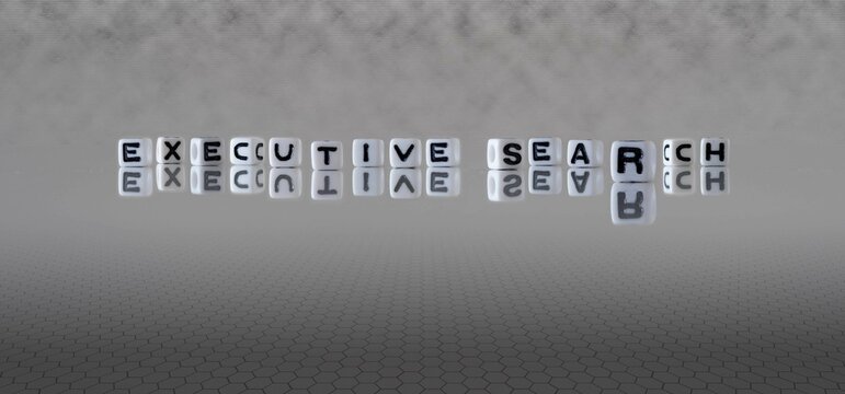 executive search word or concept represented by black and white letter cubes on a grey horizon background stretching to infinity