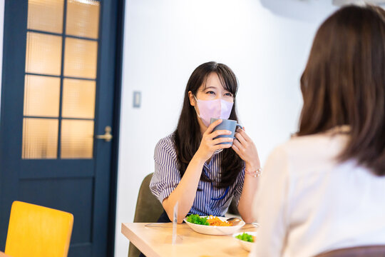 Two young women having lunch with mask on