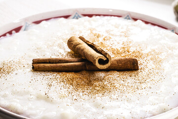 Fototapeta na wymiar sweet rice pudding, with cinnamon stick and cinnamon powder, homemade dessert, close up
