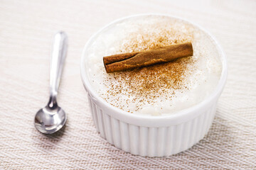 bowl with sweet rice pudding, with cinnamon stick and cinnamon powder, homemade dessert, typical sweet from Brazil at the June festivals