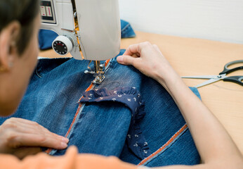 Sustainable living and fashion. A woman is sewing second-hand. Waste-free living and reuse