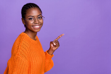 Profile photo of charming cheerful person indicate finger empty space offer isolated on purple...