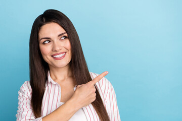 Portrait of attractive curious cheerful long-haired girl demonstrating copy space ad isolated over blue pastel color background