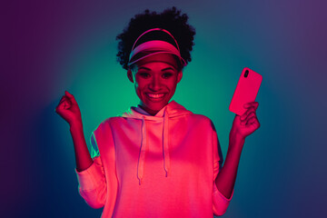 Portrait of beautiful trendy cheery girl using device like post notification isolated on bright...