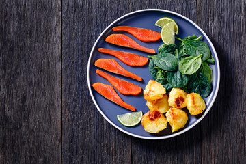 salmon slices with spinach leaves, roast potatoes