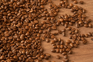 Scattered coffee beans on a wooden table. Coffee background