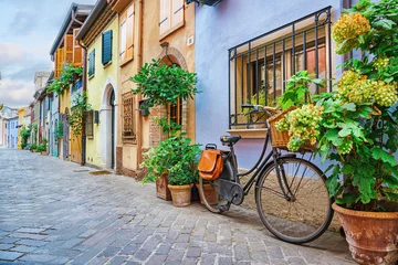 Türaufkleber Narrow street of the village of fishermen San Guiliano with colorful houses and a bicycle in early morning in Rimini, Italy © Igor