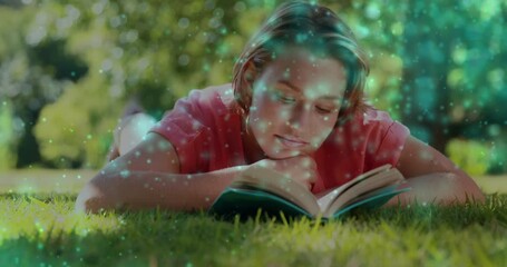 Animation of glowing spots over smiling caucasian woman reading book