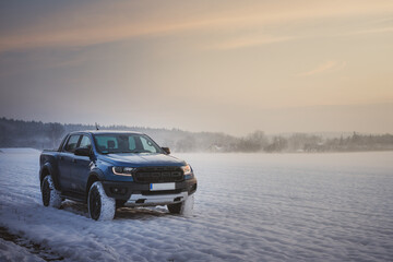 Fototapeta na wymiar Ford Ranger raptor in the snow at sunset