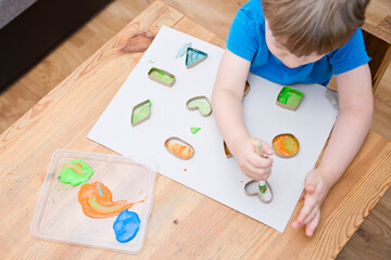 Obraz na płótnie Canvas Child learn geometric shapes. Fine motor skills. Preschool or special needs tasks. Early education of children. Montessori methodology.