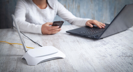 Internet router in the desk. Girl using smartphone