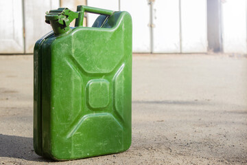 Canister of gasoline. Green Metal military style Jerrycan with Free Space for Yours text on blurred background