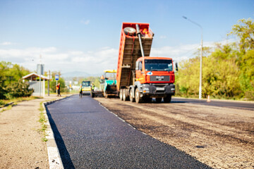 Fototapeta na wymiar Asphalt spreader in work. Construction of the road
