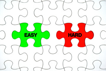 Fototapeta premium Hard and Easy words on pieces paper puzzle. To make a choice between the options of easy or hard way concept. 