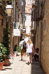 Walk between walls of houses. Passage between walls to the old town and stairs, the historical part of the city. Summer in Croatia, Dubrovnik.