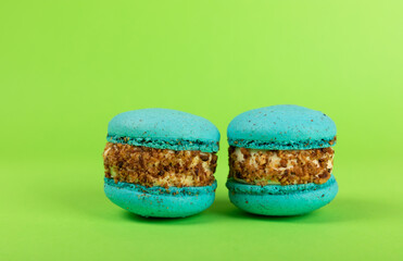 French pasta on a green background. Macarons with dor blue and pear. French dessert. Sweet table. Copy space. Place for text.