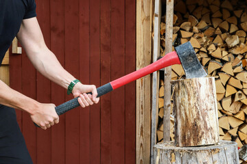 Strong man chopping firewood outdoors - 502970867